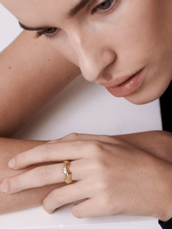 Curving gold ring with pear diamond